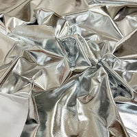 Un gros plan du Tissu lamé stretch au mètre froissé de Longan Craft France révèle sa surface brillante et réfléchissante en polyester, idéale pour la couture, les loisirs créatifs, la tapisserie et les projets nécessitant un tissu métallique flexible.