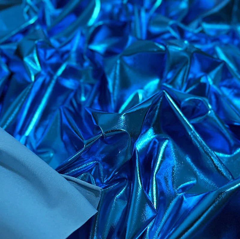 Gros plan sur un tissu lamé stretch au mètre de Longan Craft France, composé d'un tissu polyester réfléchissant dans différentes nuances de bleu et d'une petite section de tissu bleu mat. Idéal pour la couture, l'artisanat et l'ameublement.
