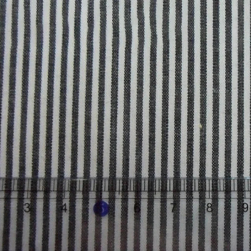 Une règle claire mesurant de 3 à 10 cm est posée sur la popeline rayée 100% coton de Longan Craft France, vendue au mètre - idéale pour les chemises, les robes et les nappes.