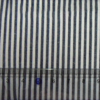 Un gros plan de Tissu en popeline de coton rayé au mètre de Longan Craft France montre une popeline de coton rayé teintée à 100 %, avec une règle en bas affichant des mesures de 4 à 8 centimètres.