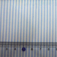 Un gros plan du Tissu en popeline de coton rayé au mètre de Longan Craft France montre des rayures bleues et blanches teintes en fil, avec une règle transparente en dessous affichant des mesures de 3 à 8 cm.
