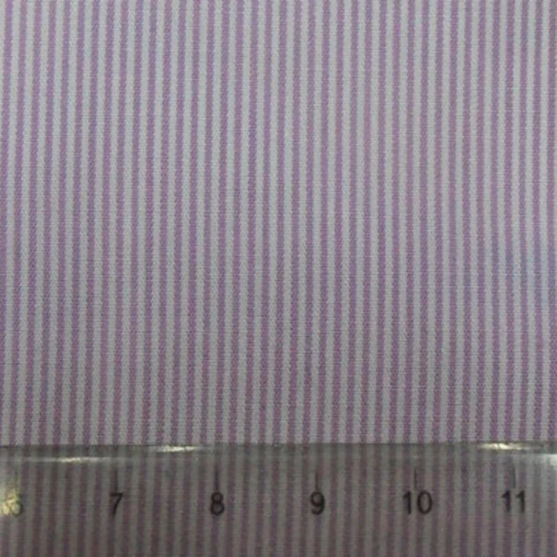 Un gros plan de Popeline tissée unie rayée au mètre de Longan Craft France montre ses bandes de coton rose et blanc, avec une règle transparente le long du bord inférieur affichant des mesures de 7 à 12 centimètres.