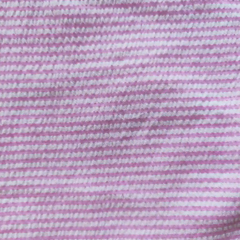 Gros plan sur le Seersucker rayé au mètre de Longan Craft France, un tissu polyester-coton aux rayures colorées. Grâce à sa surface douce et texturée, ce tissu seersucker est parfait pour des tenues d'été fraîches et confortables.