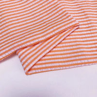 Un gros plan du Seersucker rayé au mètre de Longan Craft France montre des rayures horizontales colorées et un bord plié - idéal comme tissu seersucker polyester-coton léger pour une tenue d'été confortable et aérée.
