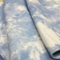 Gros plan sur le Tissu denim en coton tie-dye au mètre par Longan Craft France, 10 oz, bleu clair à motifs nuage façon denim. Ce tissu imprimé est idéal pour vêtements en jean ou décoration intérieure.