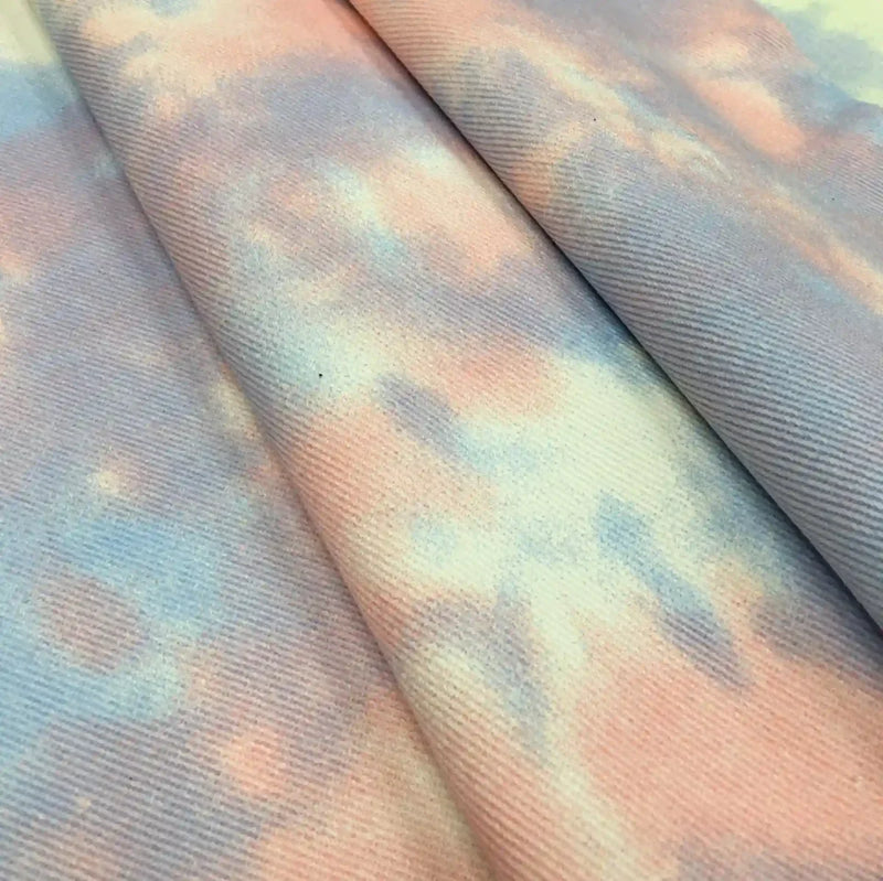 Gros plan sur le Tissu denim en coton tie-dye au mètre de Longan Craft France, un denim de 10 oz en pêche pastel, lavande et bleu pâle, dont la texture fine et les teintes délicatement mélangées sont parfaites pour des vêtements en jean vibrants faits à la main.