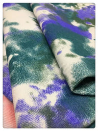 Gros plan sur le Tissu denim en coton tie-dye au mètre de Longan Craft France, un tissu denim coloré de 10 oz en vert, violet et blanc - idéal pour une décoration intérieure unique ou des vêtements en jean personnalisés.