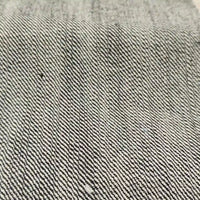 Gros plan sur le tissu en jean selvedge 16,5 oz de Longan Craft France - 100 % coton denim lourd - qui présente une texture et un tissage détaillés à rayures diagonales grises et blanches.