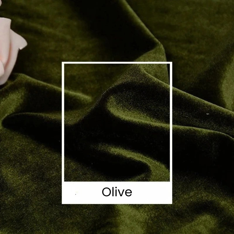 Gros plan sur le velours Tissu vert olive uni au mètre de Longan Craft France, aux plis souples et à la texture luxueuse. La mention "Olive" apparaît sur un carré blanc, mettant en valeur ce velours d'ameublement de 165 cm de large pour des projets créatifs.