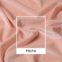 Gros plan sur le tissu velours uni au mètre de Longan Craft France : un luxueux tissu d'ameublement de couleur pêche (165 cm de large) à la texture douce et veloutée et aux plis subtils, sur lequel figure la mention "Pêche" dans un encadré central blanc.
