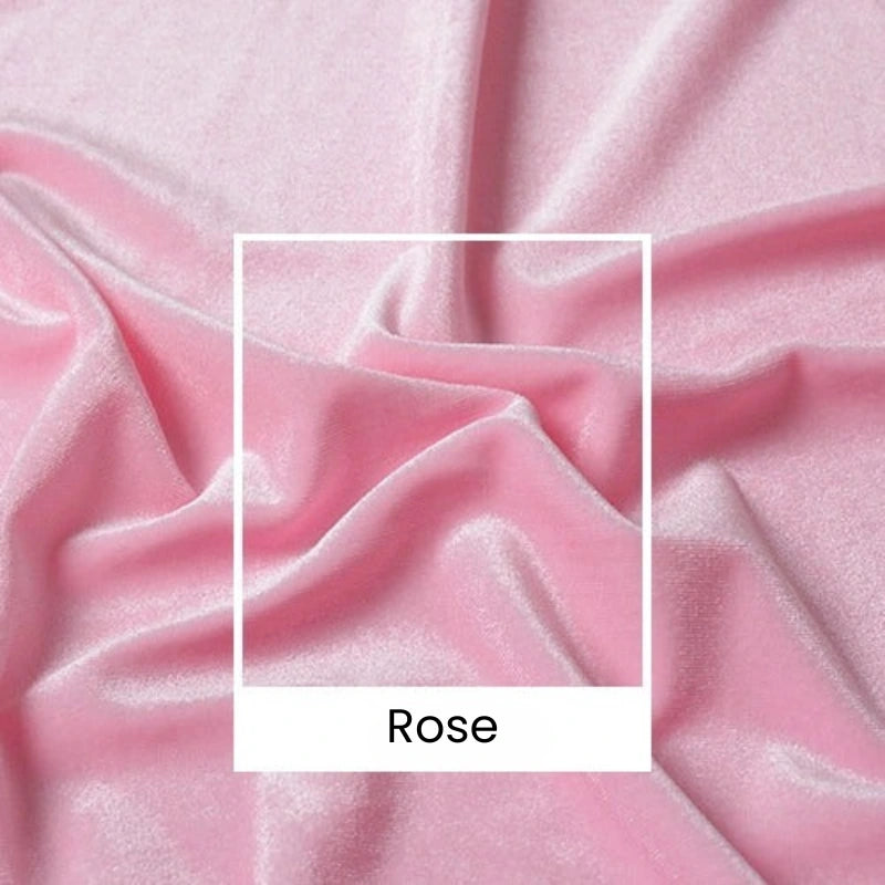 Un gros plan du tissu velours rose pâle uni au mètre de Longan Craft France montre des plis et des froissements. Une boîte blanche étiquetée "Rose" recouvre ce luxueux velours large (165 cm), parfait pour la couture, l'habillement et les projets créatifs.