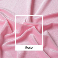 Un gros plan du tissu velours rose pâle uni au mètre de Longan Craft France montre des plis et des froissements. Une boîte blanche étiquetée "Rose" recouvre ce luxueux velours large (165 cm), parfait pour la couture, l'habillement et les projets créatifs.