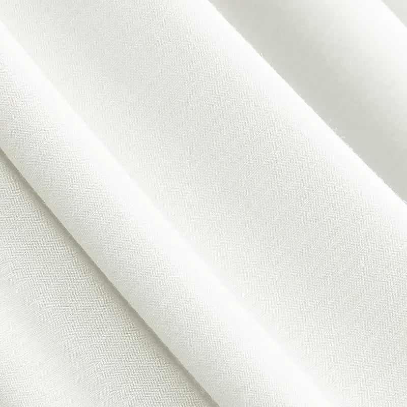 Gros plan sur le jersey modal uni au mètre de Longan Craft France, un mélange doux et mat de coton et de modal au tissage subtil - textile respirant idéal pour les vêtements de nuit. Les plis drapés mettent en valeur sa texture lisse.