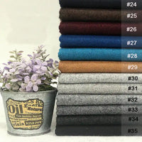 Une pile de tissu flanelle en laine et polyester de Longon Craft France dans des couleurs unies (#24-#35) est disposée à côté d'un pot de lavande en métal, mettant en valeur ce confortable textile d'intérieur parfait pour l'automne.