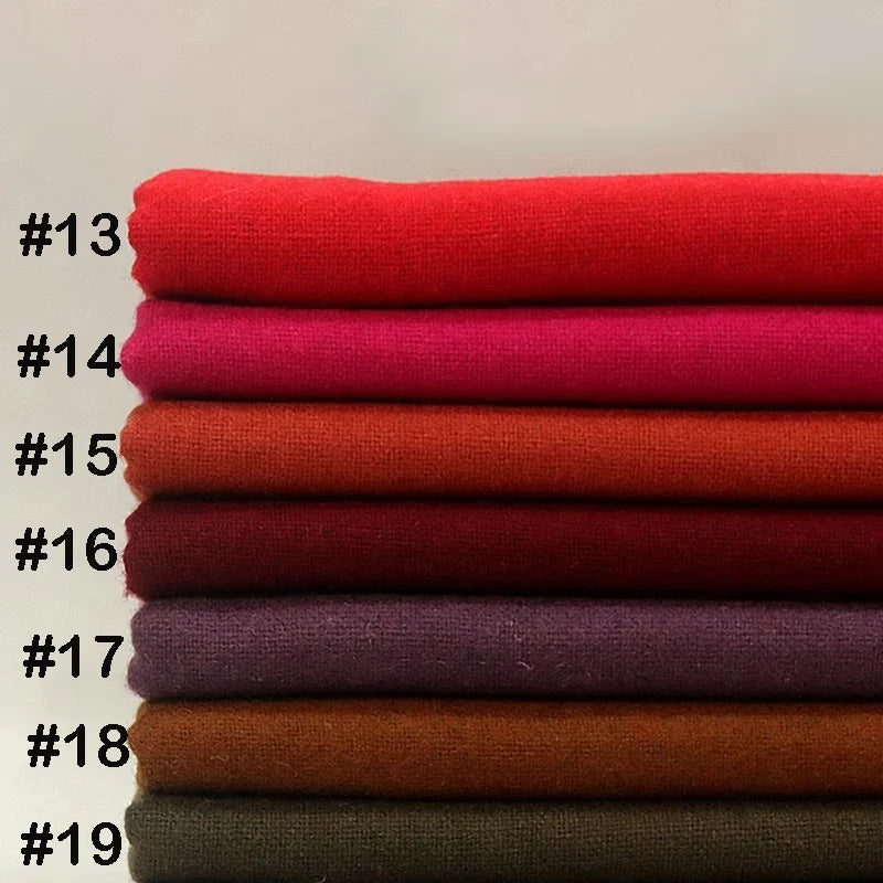 Une pile de tissu flanelle laine-polyester de Longon Craft France, étiquetée de #13 à #19, présente des teintes allant du rouge au marron foncé, idéales pour les vêtements d'hiver d'automne, pliées sur un fond neutre.